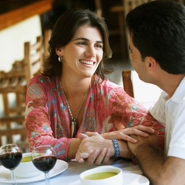 Couple enjoying a warm, intimate conversation over dinner with wine.