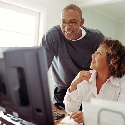 Two people looking at the laptop and talking 