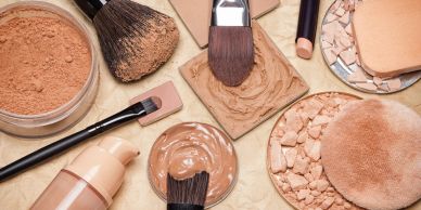 Various makeup powders and brushes arranged on a surface.