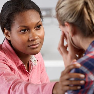 A girl talking with another lady in a room