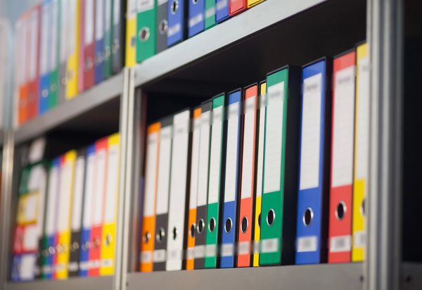 Colorful document binders neatly arranged on a shelf.
