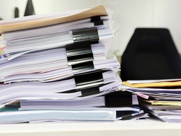 Stack of documents clipped together on a desk.