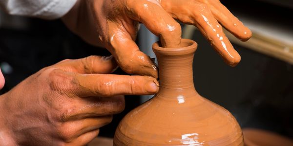 closeup shot of hands crafting clay pot 