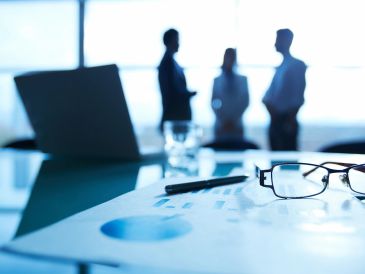 Business meeting with focus on documents and glasses.