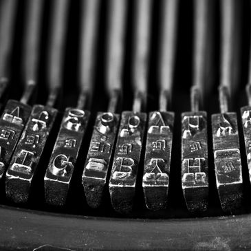 Close-up of typewriter typebars with letters.