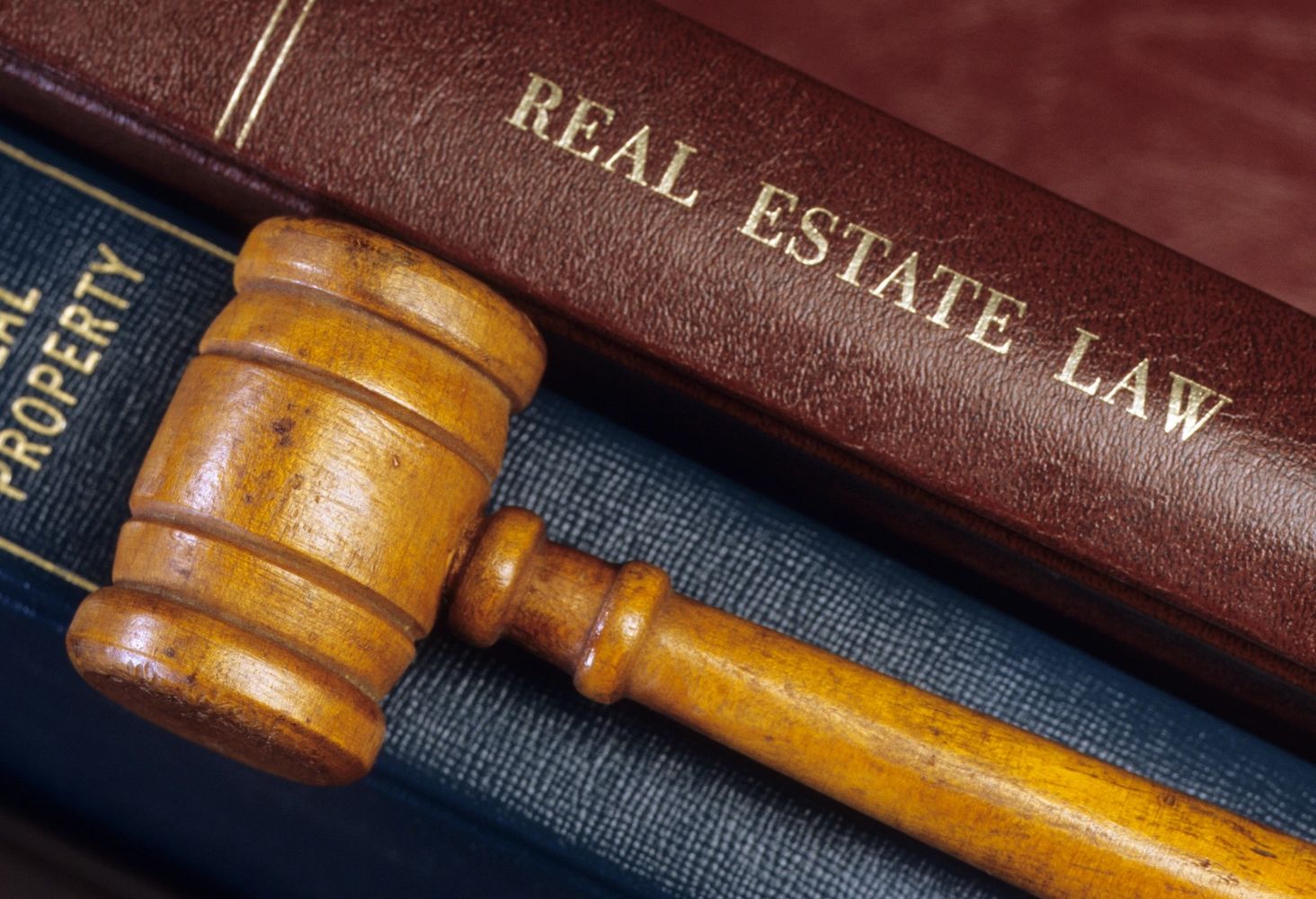 A charming gray house on a grassy hill by the ocean under a clear blue sky.