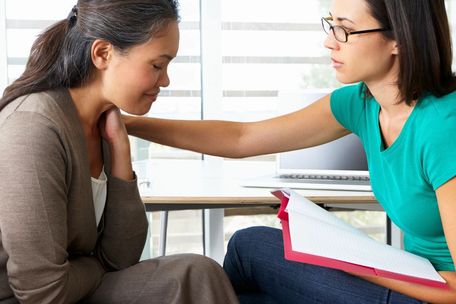 Two people are facing each other. One is offering the other emotional support.