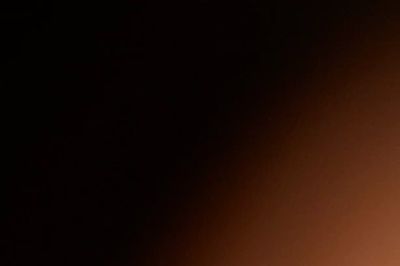 A gradient from dark black to warm brown lighting.