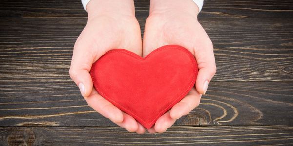 handings holding a stuffed heart 