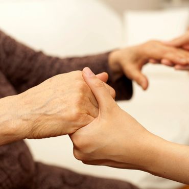 Caregiver holding hands with a resident.