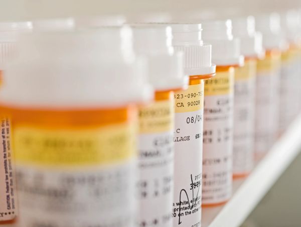 Row of prescription medication bottles lined up on a shelf.