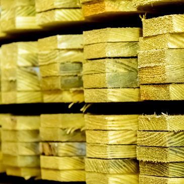 Stacked lumber planks in a warehouse.