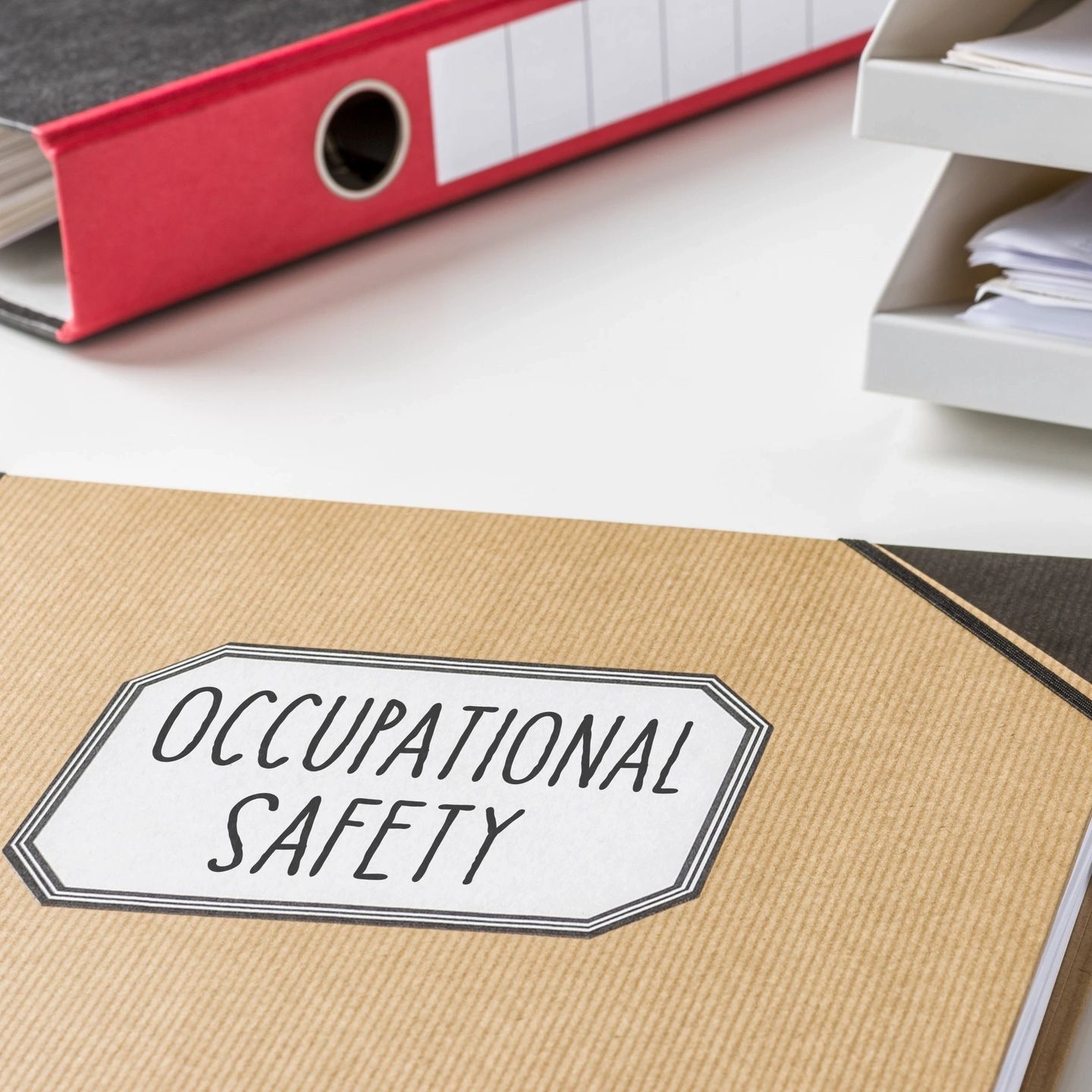 A folder labeled "Occupational Safety" on a white desk.