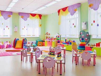 Bright and colorful children's playroom with toys and small tables.