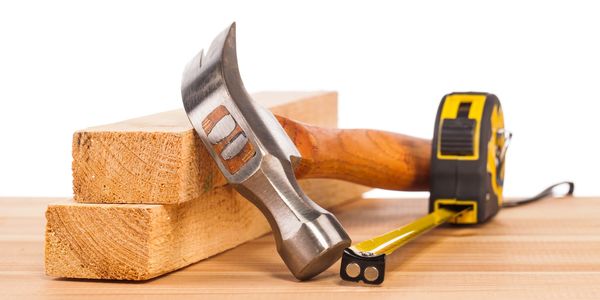 Photo of two pieces of wood, hammer and tape measure. 