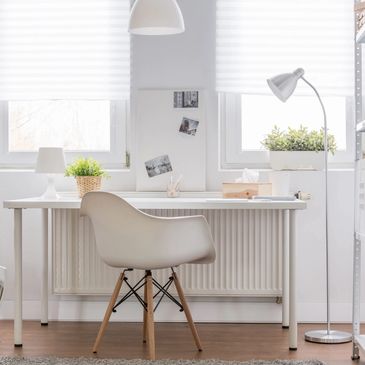 white office, with white chair at white desk, small plant in the window