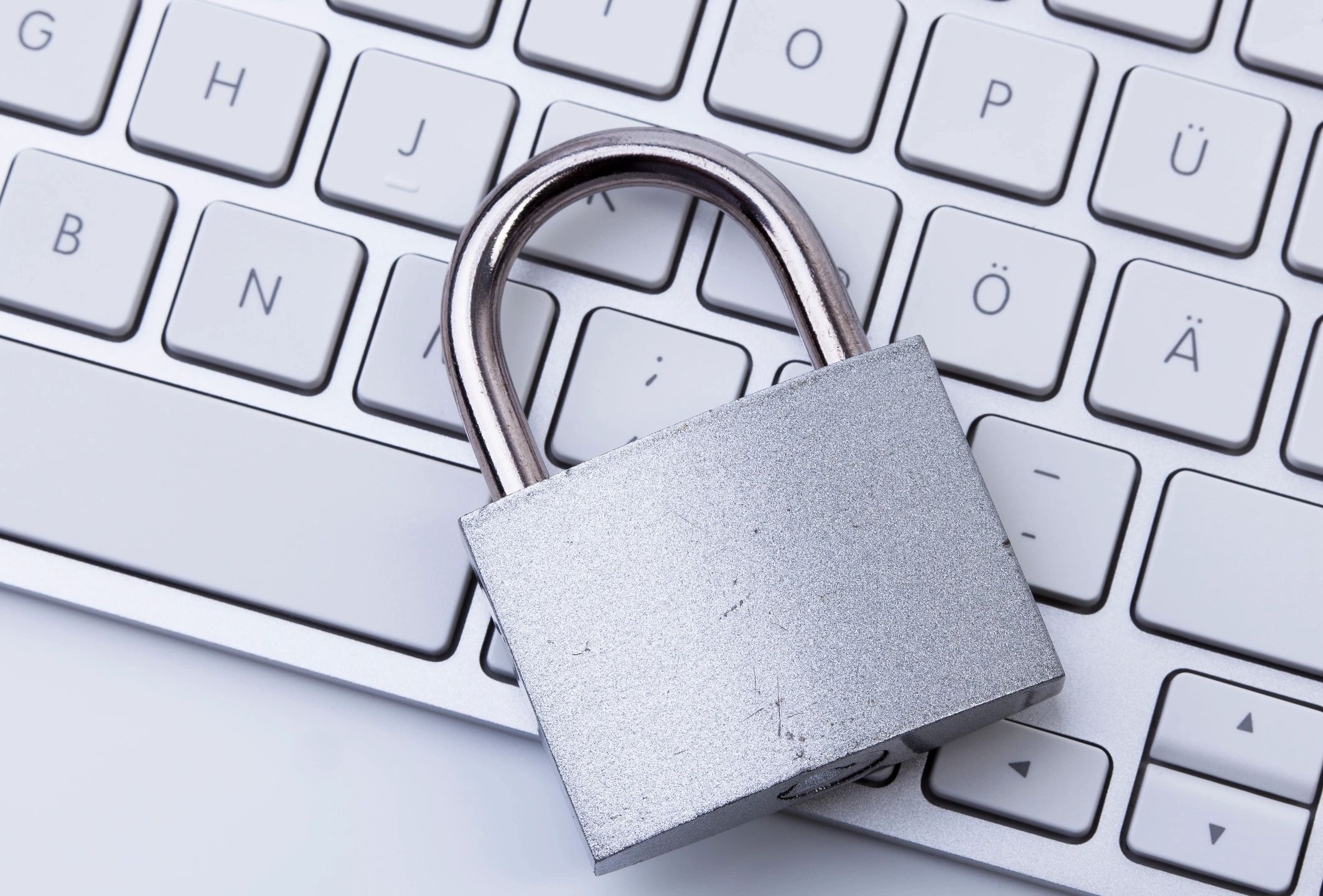 A padlock is sitting on top of a white keyboard