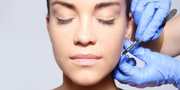 Close-up of woman receiving facial treatment.