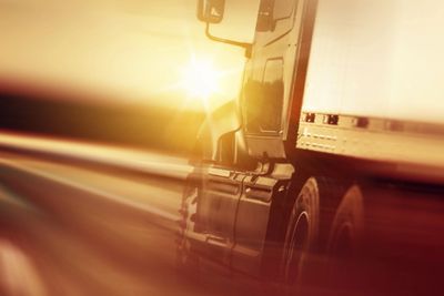A truck driving at sunset with motion blur.
