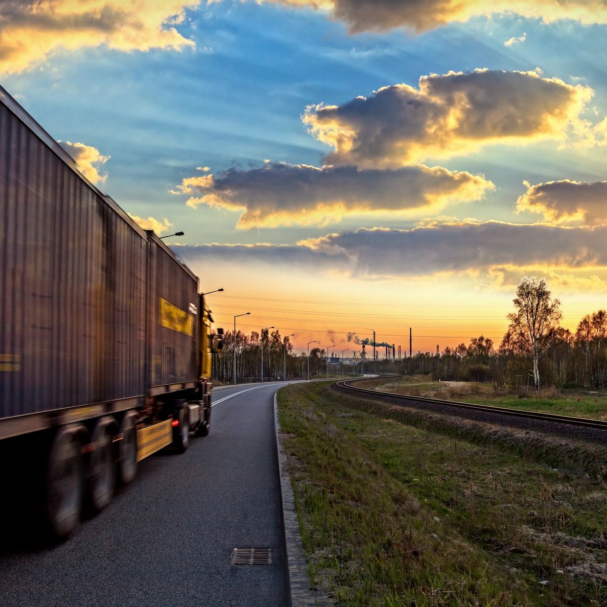 A truck driving into the sunset