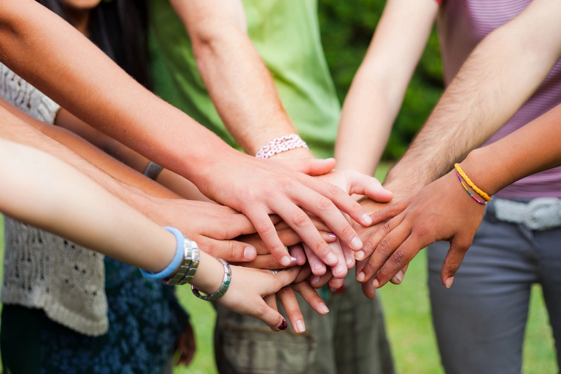A group of people with their hands stacked in the center.