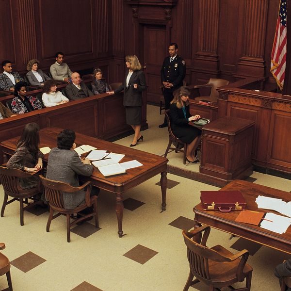 A female lawyer addressing the jury in a courtroom during a trial.