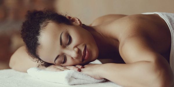 A woman asleep on a massage table.