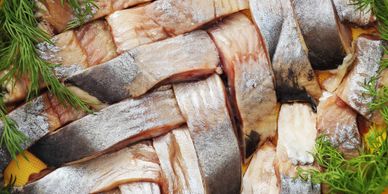 Close-up of woven fish strips garnished with fresh dill.