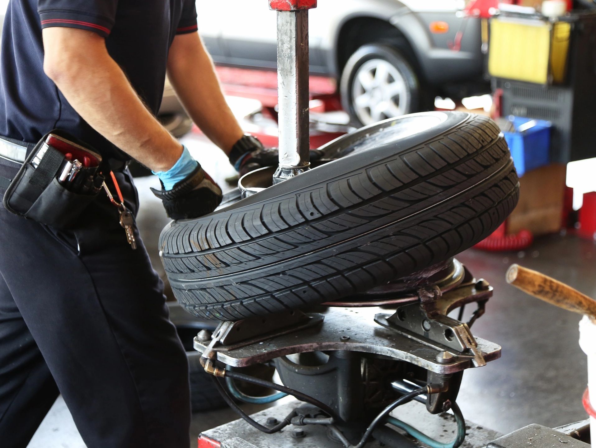 Mechanic using a tire changing machine to mount a tire.
