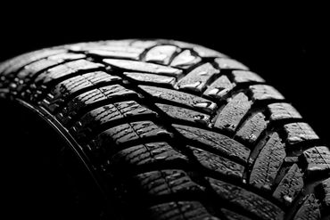 Close-up of a tire tread in black and white.