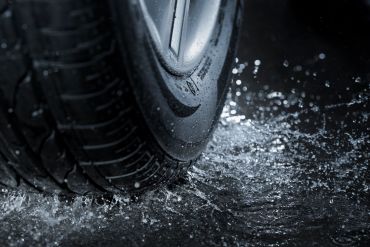 Close-up of a wet tire on a slick surface.