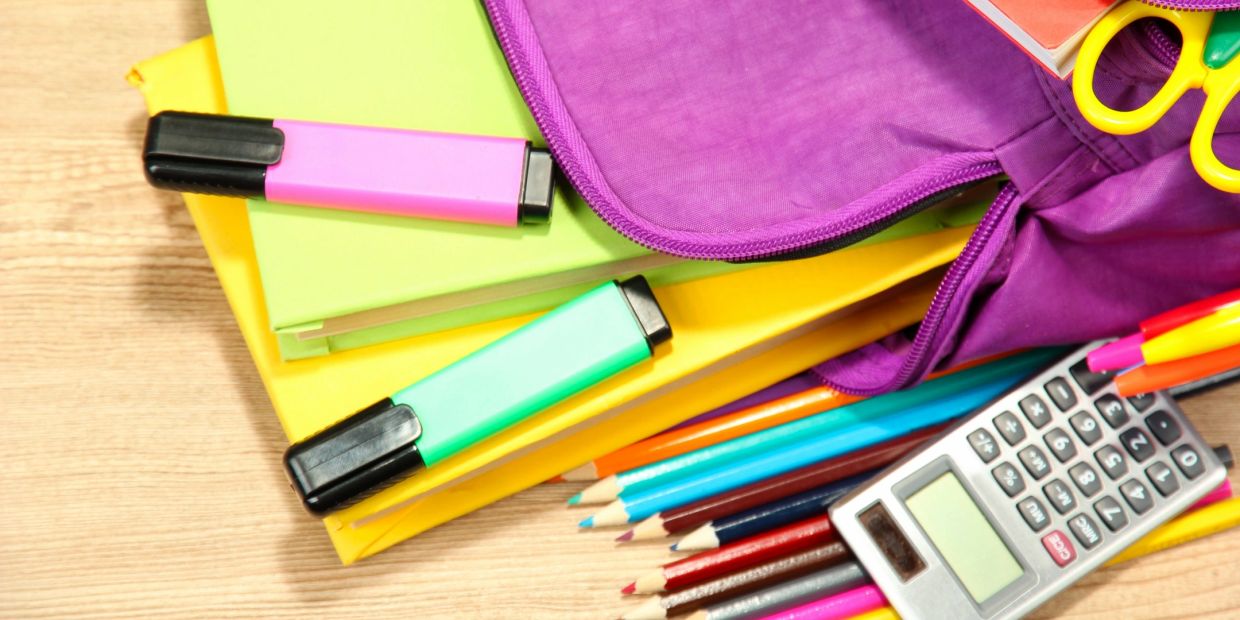 Colorful school supplies and stationery on a wooden surface.