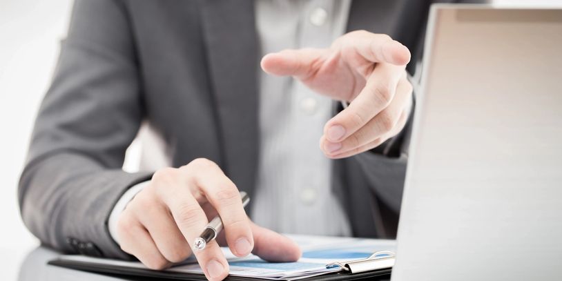 Businessman pointing at a document with pen in hand.