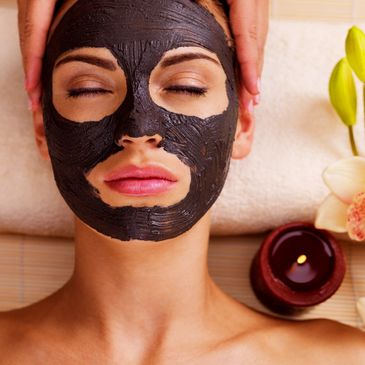 A person lying down with a facial cream in a parlor