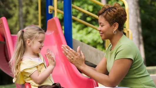 Babysitter playing with child at the park