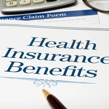 Document titled Health Insurance Benefits with a pen and calculator nearby.