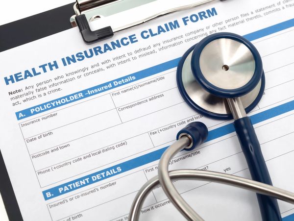 A health insurance claim form with a stethoscope on top.