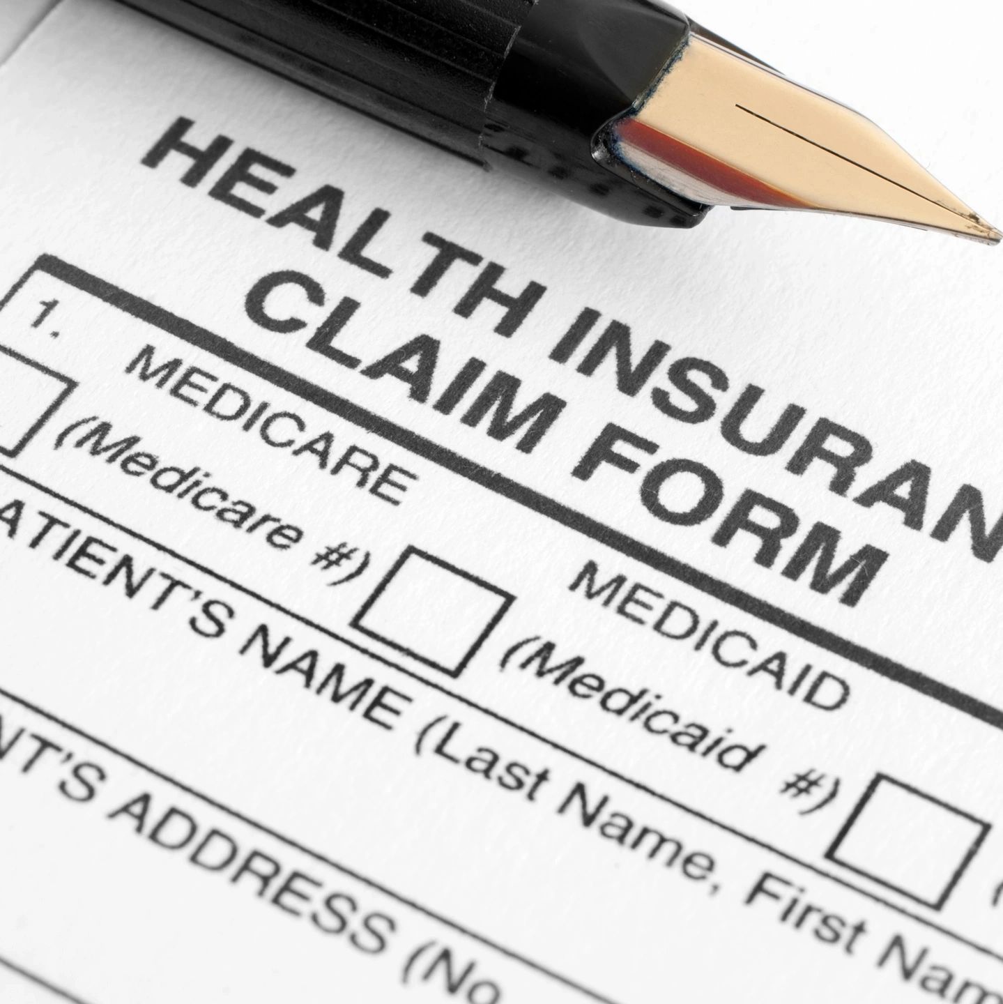 Close-up of a health insurance claim form with a fountain pen.