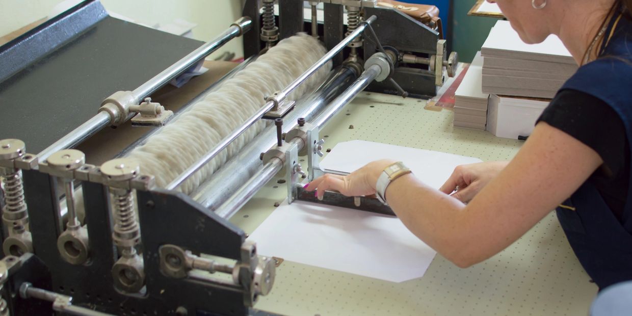 Person using a paper cutting machine.