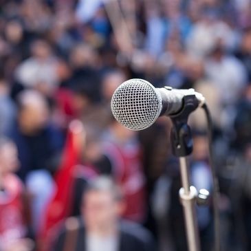 A microphone awaits Dan Leaf to speak in front of a crowd