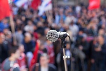 Microphone focused with a blurred crowd in the background.