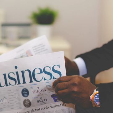 A picture of some hands holding a business newspaper.