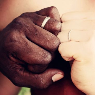 Two hands of people wearing rings