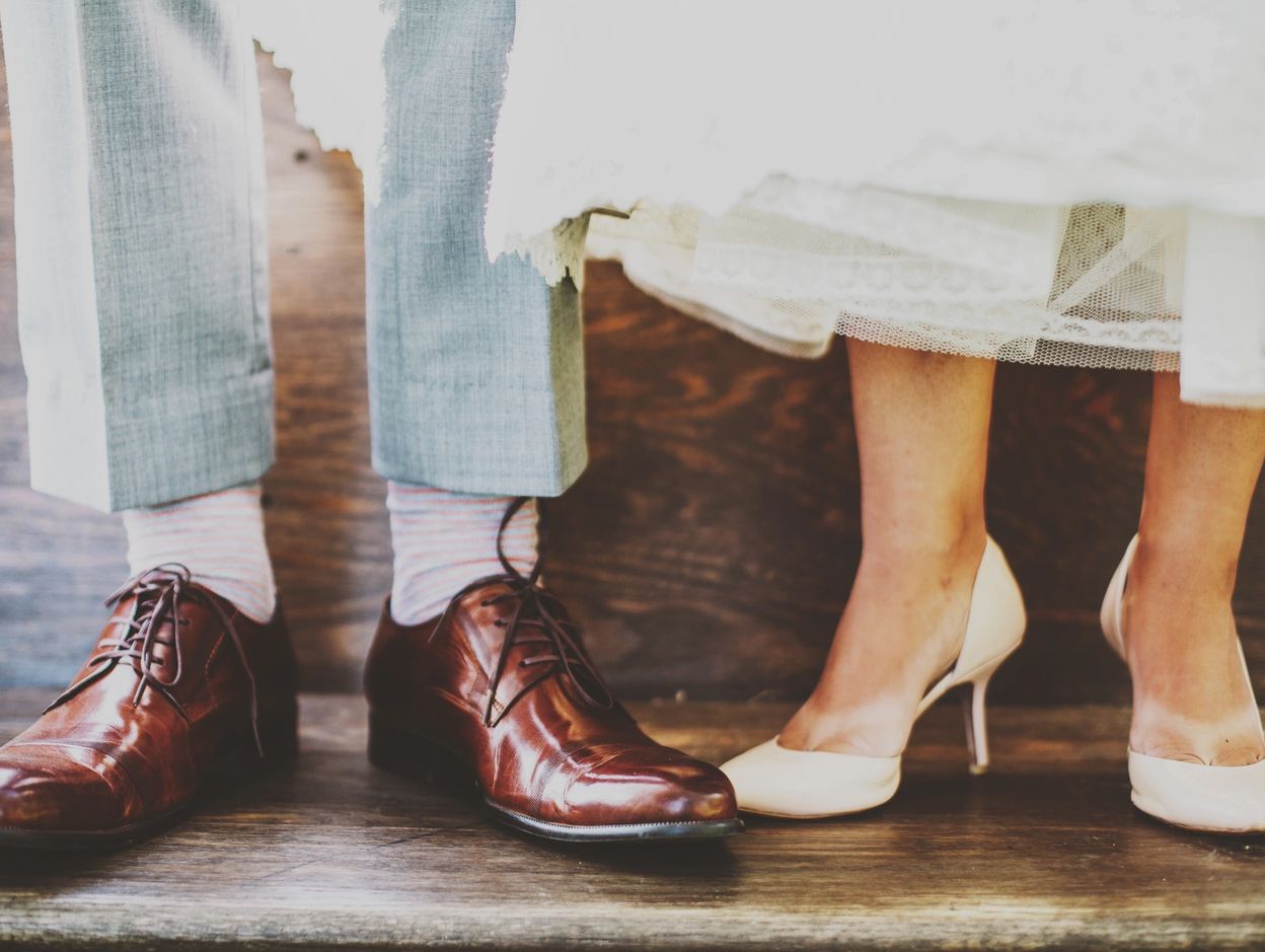 Close-up of bride and groom shoes.