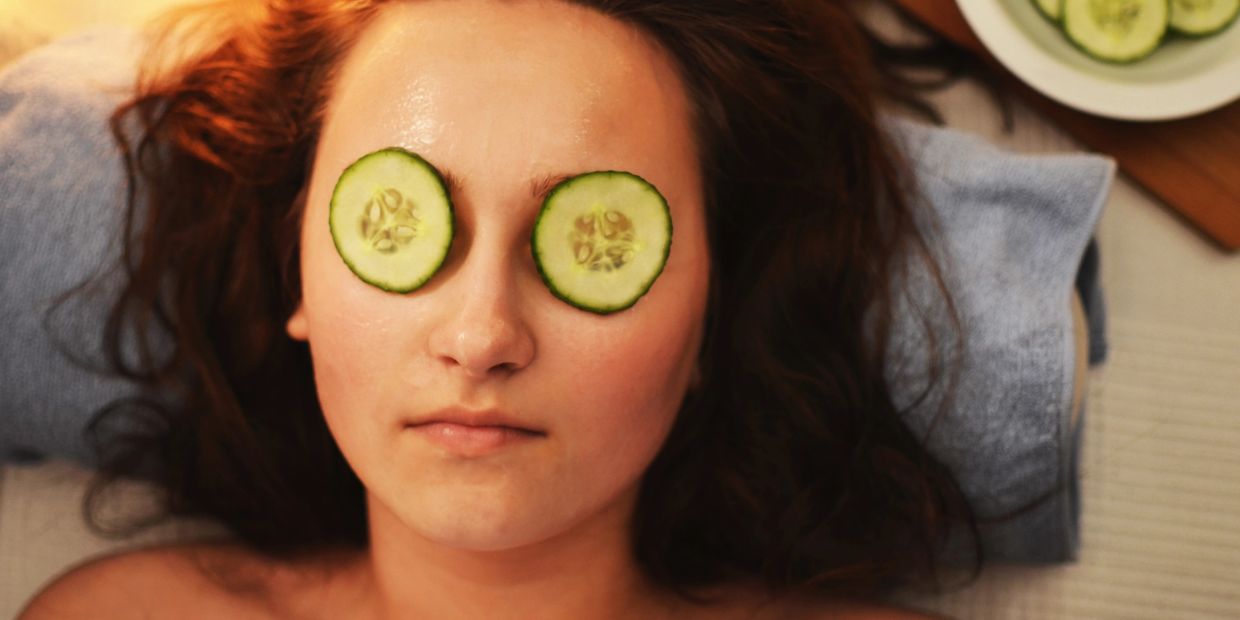 Woman with cucumber slices on her eyes relaxing.
