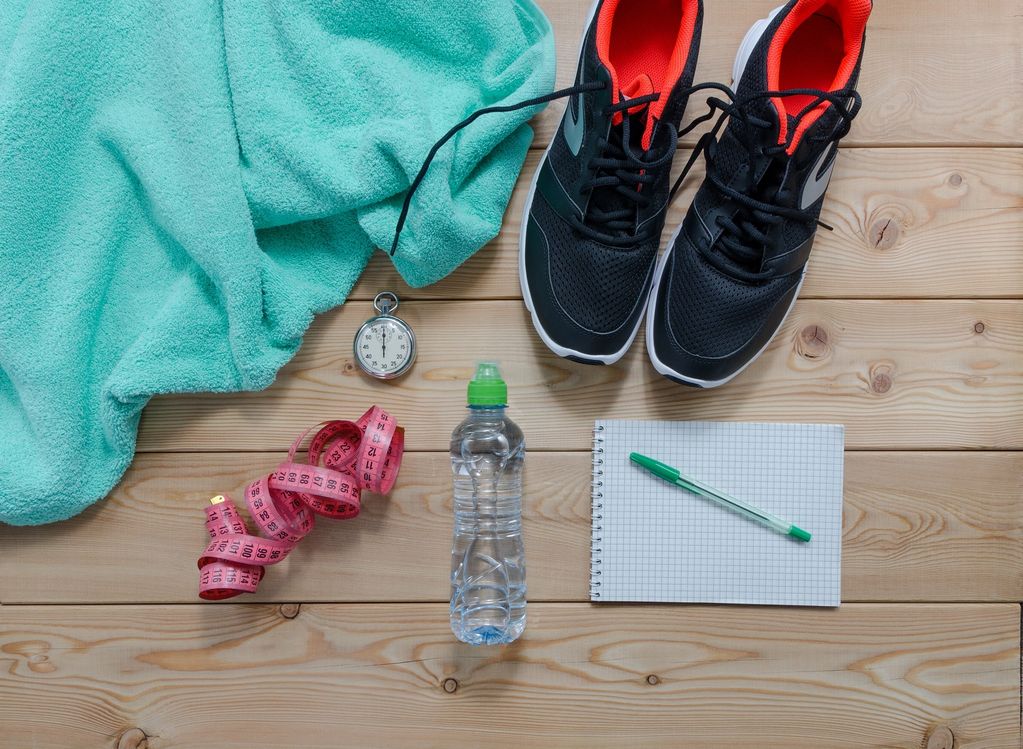 Fitness essentials including sneakers, towel, stopwatch, measuring tape, water bottle, and notebook.
