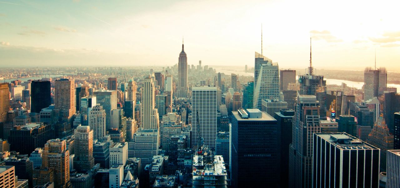 A sky top view of a major metropolitan city with downtown skyscrapers nearest and the outskirts of the town show in the distance. 