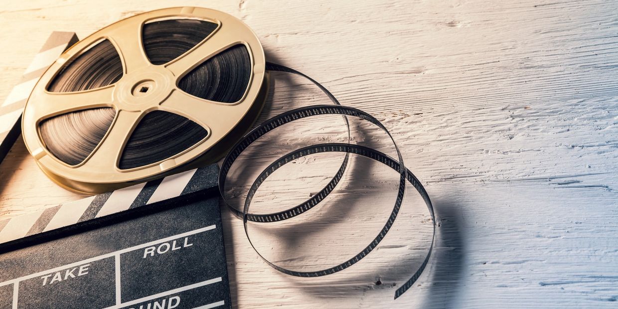 Film reel and clapperboard on the ground