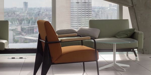 Modern office lounge with stylish chairs and city view.