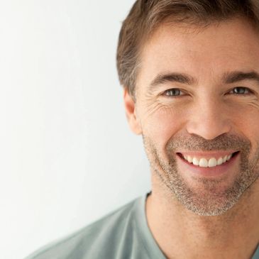 A closeup photo shows a satisfied gentleman with a beautiful smile.